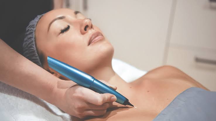 Clinician examining a patient's skin in a professional dermatology consultation room